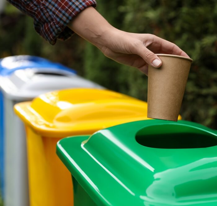 person recycling a paper cup