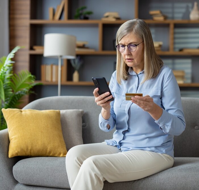 woman holding a credit card and a smartphone