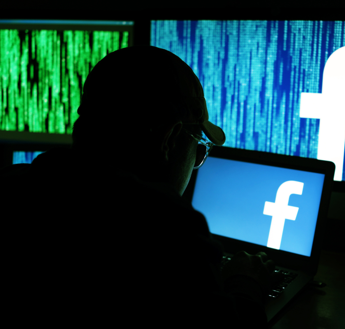 man looking a Facebook in a dark room