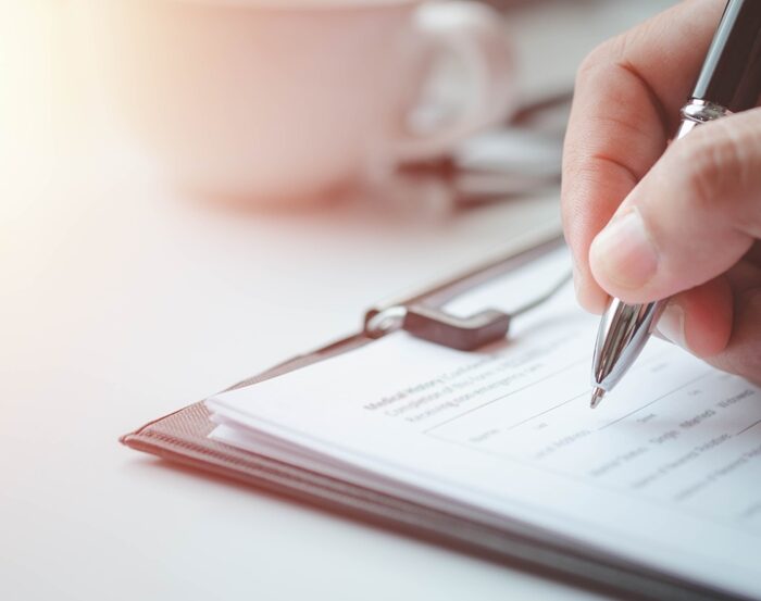 person writing on a paper document