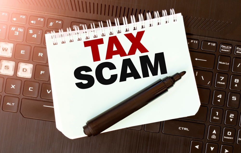 "Tax Scam" on a notepad with a felt pen