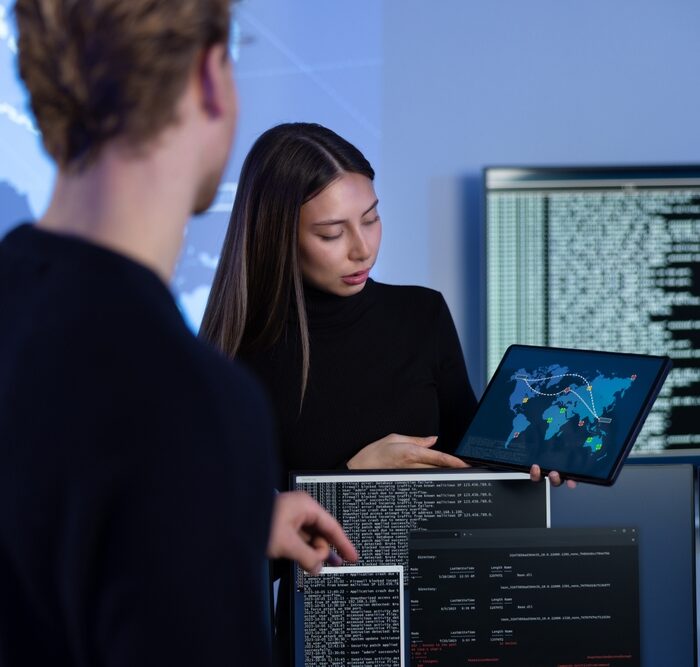 two workers reviewing a security threat on a tablet