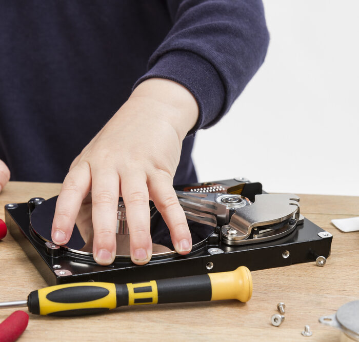 person disassembling a hard drive