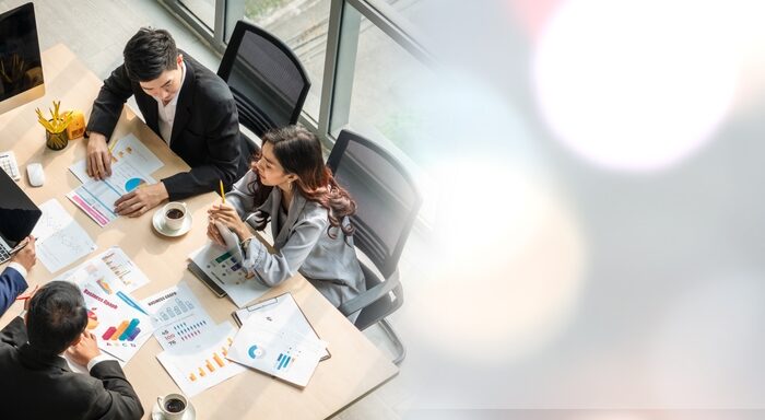 four people working at at a desk