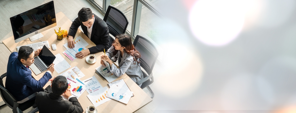 four people working at at a desk