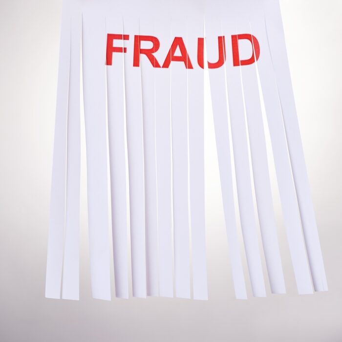 partially shredded page with the word "Fraud" in red letters