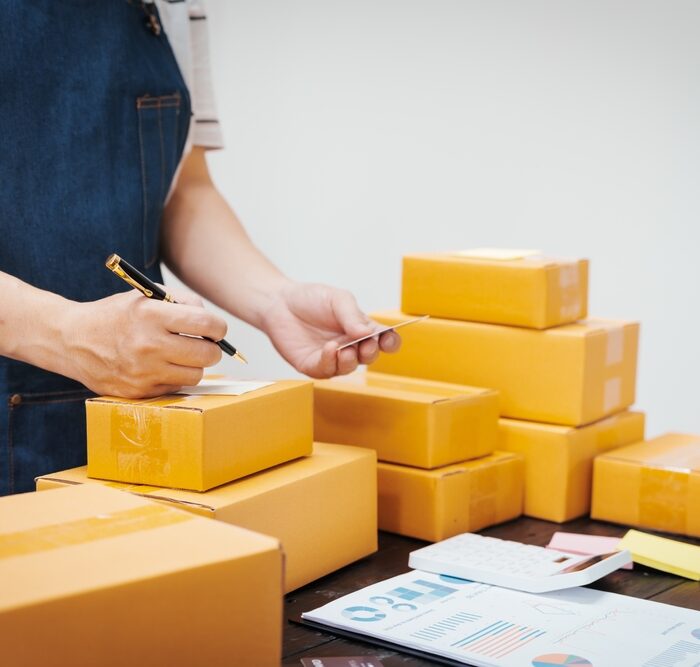 person labeling cardboard boxes