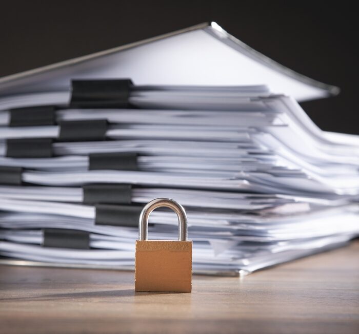 pile of papers with a padlock in front of them