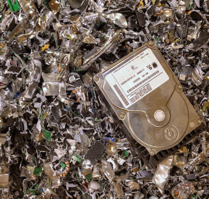 whole hard drive atop a pile of shredded hard drives