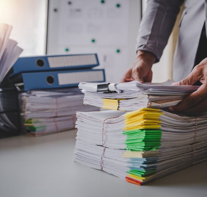 person picking up piles of paper