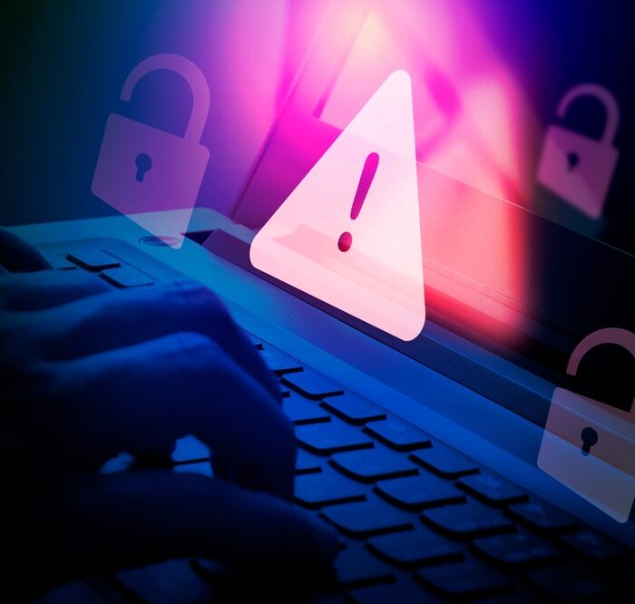 graphic of a security risk alert over a laptop