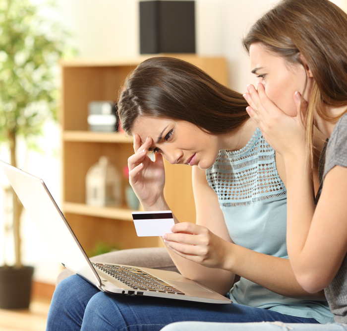 concerned women holding a credit card and a laptop