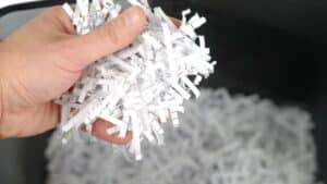 A person holding a handful of shredded paper