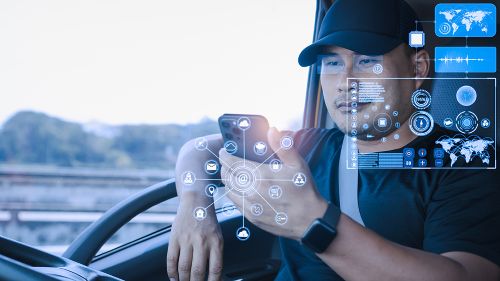 A truck driver is using his mobile phone to navigate and select different virtual options.