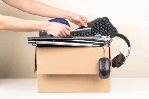 Female hands put tablet computer and keyboard in box