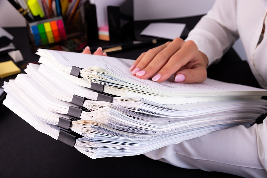 Office worker holding a stack of documents.
